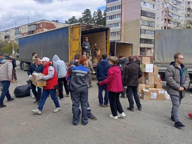 Волонтёры грузят коробки в фуру